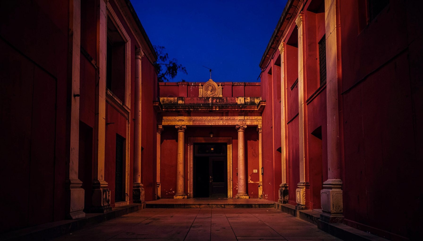 Telugu film set with dramatic lighting, rich crimson and gold color palette