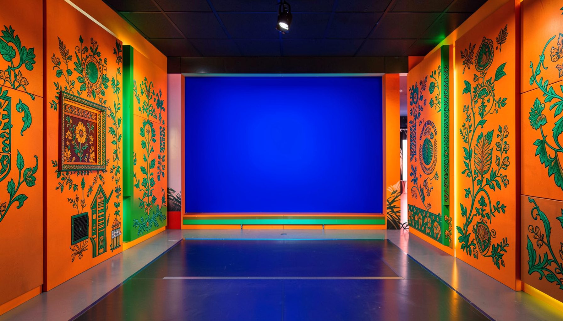 Regional television production room with vibrant Punjabi cultural motifs in orange and green